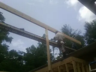 Carpenter setting a ridge beam over a new addition frame — Ice Dam Removal by Roofing Brothers in Crewe