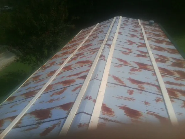 Rusted metal roof panels with new wood purlins before replacement — Storm Damage Roof Repair in Crewe by Roofing Brothers