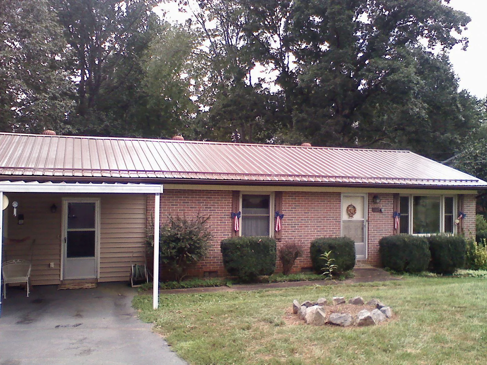 Bronze metal roof and carport on a brick ranch home — Roof Repair work by our crew in Crewe